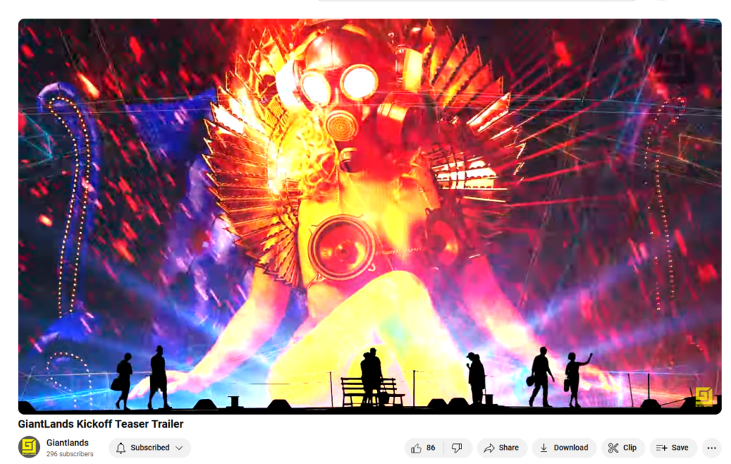 A screenshot of a YouTube video which seems to be depicting people on stage in front of a light projection of a woman in a gas mask, post-apoc theme burlesque outfit with speakers over her otherwise bare breasts.