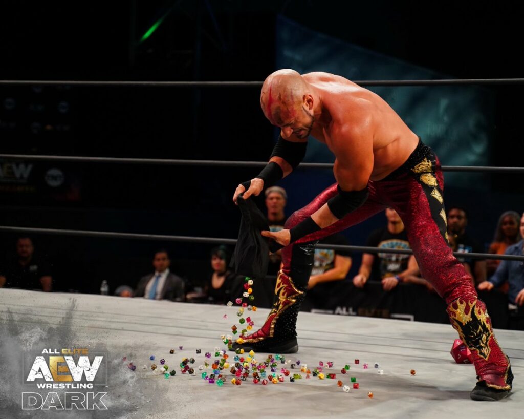 An AEW wrestler pouring a bag of dice out onto the ring, naturally he looks very dramatic.