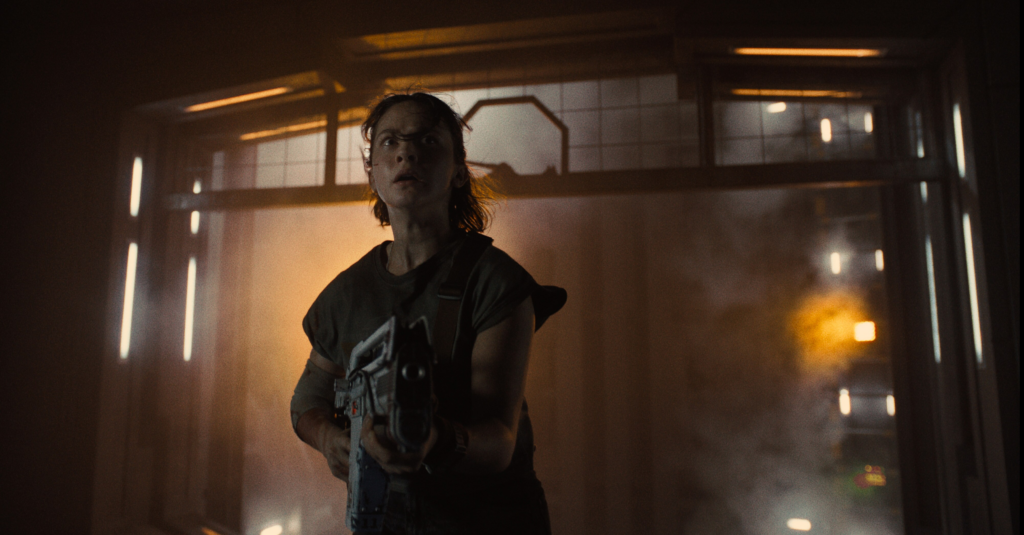 A promo shot of Cailee Spaeny as Rain, the final girl, with gun in hands. Courtesy of Disney press kit.